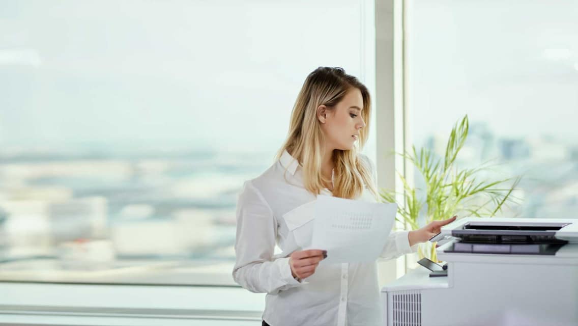 Büroangestellte holt Drucke per Follow'2'Print am Drucker ab.